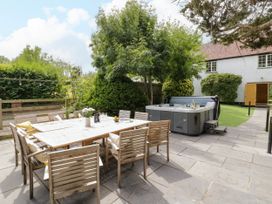 A garden with a dining table and a hot tub at Lower Tundridge Cottage Suckley near Malvern