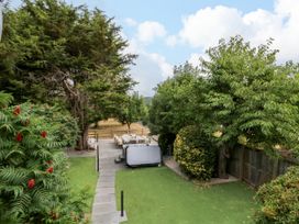 A garden with trees and seating area at Lower Tundridge Cottage in Suckley near Malvern