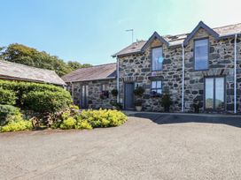 An exterior view of a stone house with plants at Wern Olau Cottage in Groeslon near Caernarfon