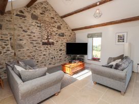 A living room with sofas and a television at Wern Olau Cottage in Groeslon near Caernarfon
