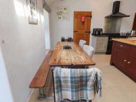 A kitchen with a wooden table and chairs at Wern Olau Cottage Groeslon near Caernarfon