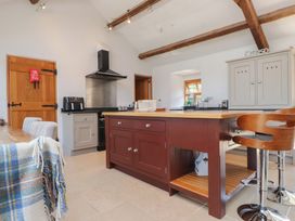 A kitchen with a kitchen island and stools at Wern Olau Cottage Groeslon near Caernarfon