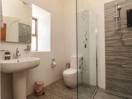 A bathroom with a sink, toilet and shower at Wern Olau Cottage in Groeslon near Caernarfon