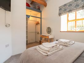 A bedroom with a bed and wardrobe at Wern Olau Cottage in Groeslon near Caernarfon
