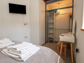 A bedroom with a bed and a dressing table at Wern Olau Cottage in Groeslon near Caernarfon
