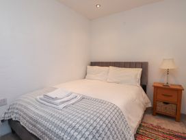 A bedroom with a bed and side table at Wern Olau Cottage Groeslon near Caernarfon