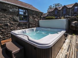 A hot tub on a wooden deck at Wern Olau Cottage in Groeslon near Caernarfon
