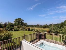 A garden with a hot tub and outdoor furniture at Wern Olau Cottage in Groeslon near Caernarfon