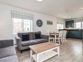 A living room with a sofa and dining area at Coastal Cottage The Bay near Filey
