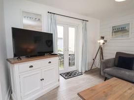 A living room with a television and a sofa at Coastal Cottage The Bay near Filey