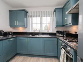 A kitchen with cabinets and appliances at Coastal Cottage The Bay near Filey