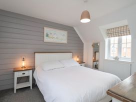 A bedroom with a bed and nightstand at Coastal Cottage The Bay near Filey