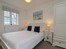 A bedroom with a bed and nightstand at Coastal Cottage The Bay near Filey