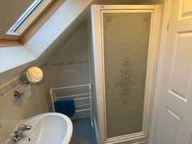 A bathroom with a shower, sink, and towel rack at The Old Cider Barn in Wookey