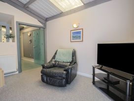 A living room with a recliner chair and television at Brookfield Lodge Drimpton