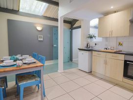 A kitchen with a dining table and blue chairs at Brookfield Lodge in Drimpton