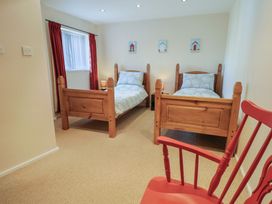 A bedroom with two beds and a chair at Brookfield Lodge in Drimpton