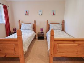 A bedroom with two single beds and side tables at Brookfield Lodge in Drimpton