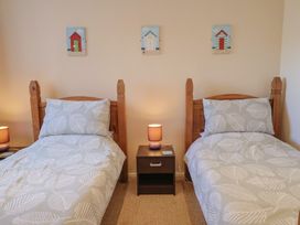 A bedroom with two beds and wall art at Brookfield Lodge in Drimpton