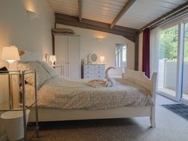 A bedroom with a bed and a dresser at Brookfield Lodge in Drimpton