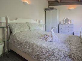 A bedroom with a bed and a wardrobe at Brookfield Lodge in Drimpton