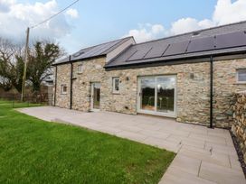 An outdoor area with stone house and patio at Storws Tanrallt