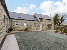 An outdoor area with a stone building and gravel ground at Storws Tanrallt