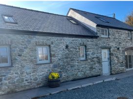 A house exterior with stone walls and a pathway at Storws Tanrallt Llanfachraeth