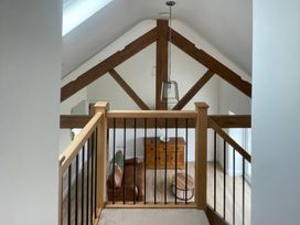 A living room view from above with a wooden railing at Storws Tanrallt Llanfachraeth