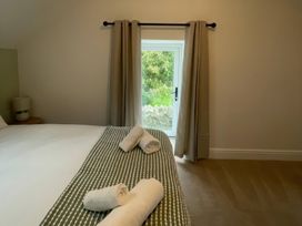 A bedroom with a bed and window at Storws Tanrallt Llanfachraeth