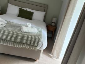 A bedroom with a bed and towels at Storws Tanrallt Llanfachraeth