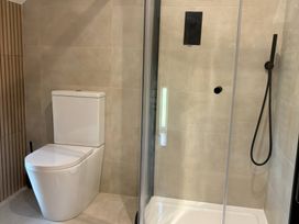 A bathroom with a toilet and a shower at Storws Tanrallt Llanfachraeth
