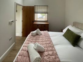 A bedroom with a bed and wooden furniture at Storws Tanrallt Llanfachraeth
