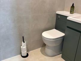 A bathroom with a toilet and vanity unit at Storws Tanrallt Llanfachraeth