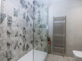 A bathroom with a shower and towel rack at 40 New Row Pwllheli