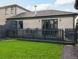 An outdoor area with a deck and fence at Hafod Wen in Pentraeth