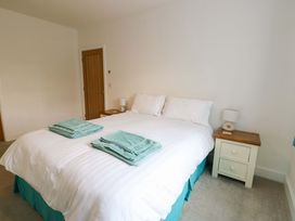 A bedroom with a bed and nightstand at Hafod Wen, Pentraeth