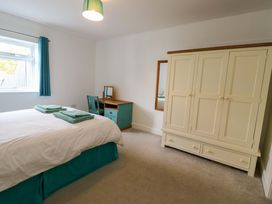 A bedroom with a bed and a wardrobe at Hafod Wen in Pentraeth