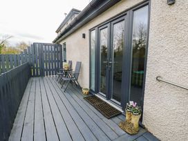 An outdoor space with seating and flower pots at Hafod Wen in Pentraeth