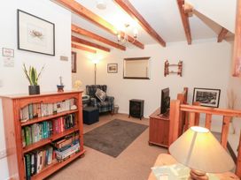 A living room with a bookshelf and a sofa at The Old Cottage in Staithes