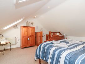 A bedroom with a bed and wardrobe at The Old Cottage in Staithes