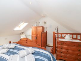 A bedroom with a bed and wooden furniture at The Old Cottage in Staithes