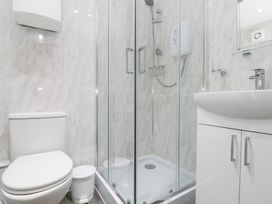 A bathroom with a shower enclosure and toilet at The Old Cottage in Staithes