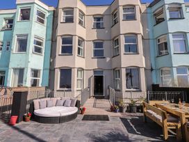 An outdoor area with seating and a dining table at Wavecrest in Pwllheli