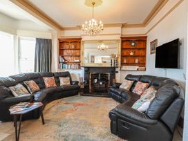 A living room with a sofa and a fireplace at Wavecrest in Pwllheli