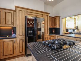 A kitchen with wooden cabinets and a refrigerator at Wavecrest in Pwllheli