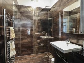 A bathroom featuring a shower, sink, and towel warmer at Wavecrest in Pwllheli