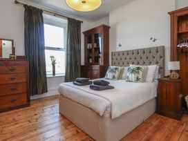 A bedroom with a bed, dresser, and window at Wavecrest in Pwllheli