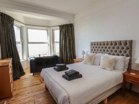 A bedroom with a bed and windows at Wavecrest in Pwllheli