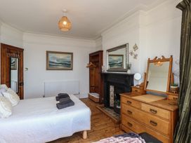 A bedroom with a bed and wooden furniture at Wavecrest in Pwllheli